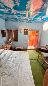 a bedroom with a bed and a painting of clouds on the ceiling at Chipaskot Spot in Pokhara