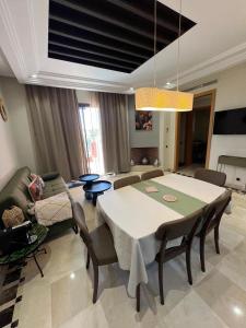 a living room with a table and a couch at Appartement de charme au Vizir Resort in Dar Caïd Layadi