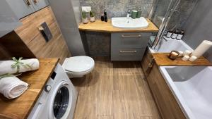 a bathroom with a sink and a washing machine at Apartament Trevo in Gdańsk