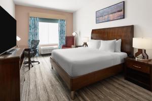 ein Hotelzimmer mit einem großen Bett und einem Schreibtisch in der Unterkunft Hilton Garden Inn Memphis/Wolfchase Galleria in Memphis + 32 Fotos