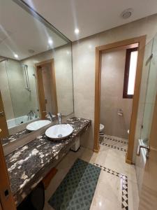a bathroom with a sink and a mirror and a toilet at Appartement de charme au Vizir Resort in Dar Caïd Layadi
