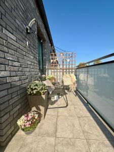 a patio with two chairs and flowers on a building at Apartament Trevo in Gdańsk