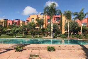 a swimming pool in front of a large building at Appartement de charme au Vizir Resort in Dar Caïd Layadi +20 photos