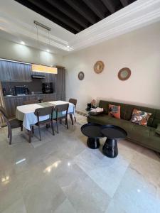 a living room with a couch and a table at Appartement de charme au Vizir Resort in Dar Caïd Layadi