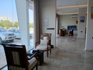 a lobby with chairs and a waiting room with cars at رؤوم إن للشقق المخدومة Raoum Inn Serviced Apartments-Shaqraa in Shaqra