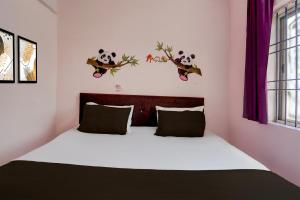 a bedroom with a bed with panda decals on the wall at Hotel O Royal Stay in Bhilai