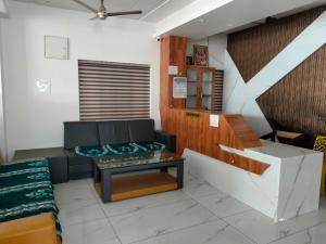 a living room with a couch and a table at Hotel O New anugraha deluxe in Kulurkudrū