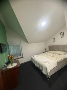 une chambre avec un grand lit et une fenêtre dans l'établissement Hotel Višnjica, à Španat