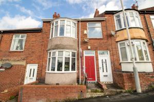 a red brick house with a red door at Kingley Court By Greenstay Serviced Accommodation - A Newly Refurbished 2 Bed Flat In Gateshead - Ideal For Contractors - Business Travellers & Relocations - 10 Mins From Newcastle City Centre - Free Parking - Fast Wi-Fi in Gateshead