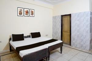 a bedroom with a bed in a room at Hotel O Radha Residency in Badarpur
