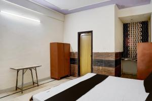 a room with a bed and a table in it at Hotel O Radha Residency in Badarpur
