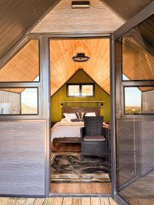 a bedroom in a tent with a bed and a chair at Peace Haven @ Windfarm Accommodation in Yzerfontein