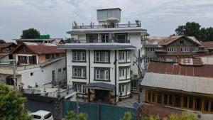 a white building with a tower on top of it at Mountain Nest A Boutique Stay Near Dal Lake, Srinagar in Srinagar