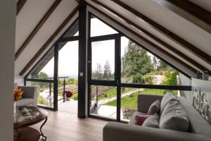 ein Wohnzimmer mit einem großen Glasfenster in der Unterkunft Cabana din padure in Agapia