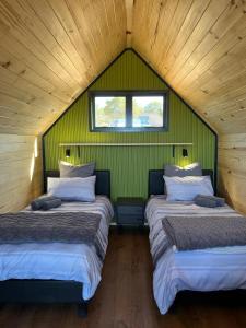 two beds in a room with a green wall at Peace Haven @ Windfarm Accommodation in Yzerfontein