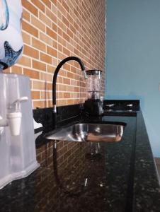 a kitchen sink with a faucet on a counter at Suíte Boa Onda Cumuruxatiba in Cumuruxatiba