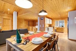 a dining room and living room with a table and chairs at Arctic Wilderness Lodge 4BDR, Sauna, Wifi & Hut in Rovaniemi