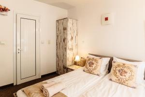 a bedroom with a bed with white sheets and pillows at Hotel Kiev in Veliko Tŭrnovo