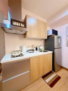 een kleine keuken met een fornuis en een koelkast bij SM Bicutan Miami Flat in Manilla