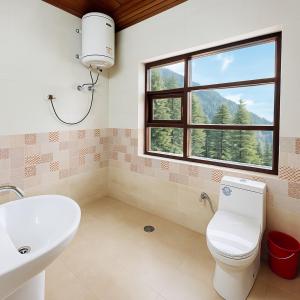 a bathroom with a sink and a toilet and a window at Himalayan Crescent 2 Bedroom Luxury independent Villas Manali in Manāli