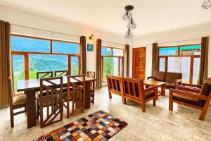 a dining room with a table and chairs and windows at Himalayan Crescent 2 Bedroom Luxury independent Villas Manali in Manāli +33 photos