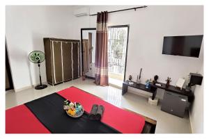 a living room with a red rug and a tv at La MAISON BLANCHE - B - CENTRAL - CALME - WIFI - White Butterfly Hotels in Dakar