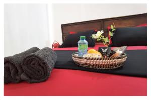 a basket of towels and a bottle of water on a bed at La MAISON BLANCHE - B - CENTRAL - CALME - WIFI - White Butterfly Hotels in Dakar