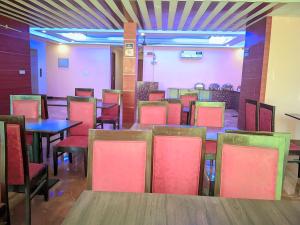 a dining room with tables and chairs at Expo Mart Inn in Greater Noida +13 photos