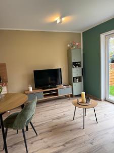 een woonkamer met een televisie en een tafel bij Ferienwohnung in den Mühlgärten in Dahn