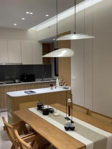 a kitchen with a wooden table and two pendant lights at M Luna Residence in Kuala Lumpur