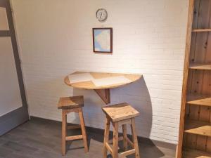 a table and two stools in front of a wall at Studio 't Krekeltje in Westkapelle