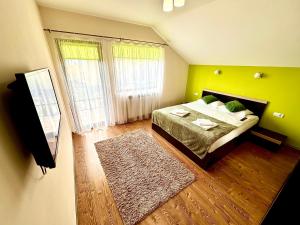 a bedroom with a bed with green walls and a rug at Casa David Comarnic in Comarnic +31 photos