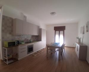 a kitchen with white cabinets and a table and a tableablish at Posidonia in Lizzano