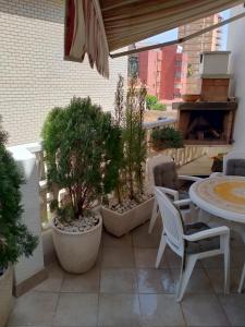 a patio with a table and chairs and potted plants at Chalet entre playas in Oropesa del Mar