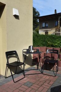 two chairs and a table with a tea kettle on it at Pokoje Mira in Torzym