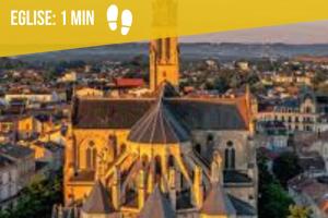 ein gelbes Gebäude mit einem Turm in einer Stadt in der Unterkunft La bohème du clocher - paisible - hyper centre in Bergerac