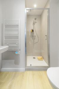 a shower with a glass door in a bathroom at Résidence Louis B - Appartements design et climatisés in Vichy