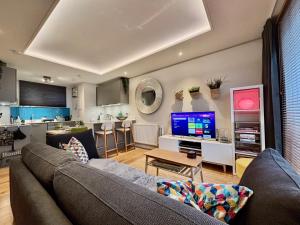 エディンバラにあるModern tranquil beach retreat - warm studio with fast links to city centreのリビングルーム(ソファ、テレビ付)、キッチン