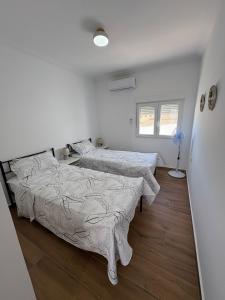 Habitación con 2 camas, paredes blancas y suelo de madera. en Stella Villa Mojacar, en Mojácar 19 fotos más