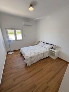 1 dormitorio blanco con 1 cama y suelo de madera en Stella Villa Mojacar, en Mojácar