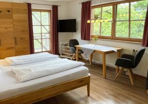 ムルナウ・アム・シュタッフェルゼーにあるSporerhofのベッドとテーブルと椅子のあるホテルの部屋