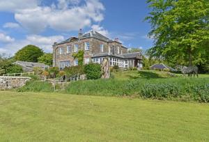 a large house on top of a hill with a grass field at Bedford House in Brentor