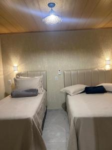 Zimmer mit 2 Betten und einer Lampe in der Unterkunft Suite Tarituba 1 in Paraty