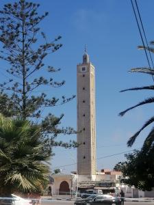 a tall tower with cars parked in front of it at Dar Sofiane in Sidi Bouzid