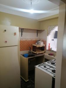 a kitchen with a white refrigerator and a stove at Dar Sofiane in Sidi Bouzid