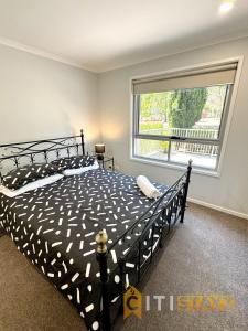 a bedroom with a bed and a large window at Comfortable & Spacious -2bd 2bth - Braddon in Canberra