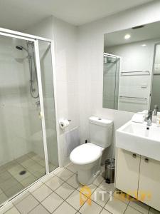 a bathroom with a toilet and a shower and a sink at Comfortable & Spacious -2bd 2bth - Braddon in Canberra +20 photos