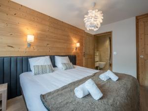 a bedroom with a large bed with towels on it at Duplex de standing 3 étoiles à Morzine, 100m des pistes, 9 pers., terrasse, garage, wifi inclus - FR-1-754-20 in Morzine