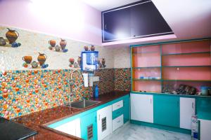 een keuken met blauwe kasten en een tegelmuur bij Nandhi home stay in Tiruvannamalai