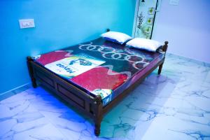 een klein bed in een kamer met een blauwe muur bij Nandhi home stay in Tiruvannamalai